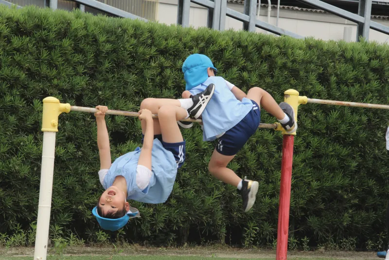 鉄棒にぶら下がる園児
