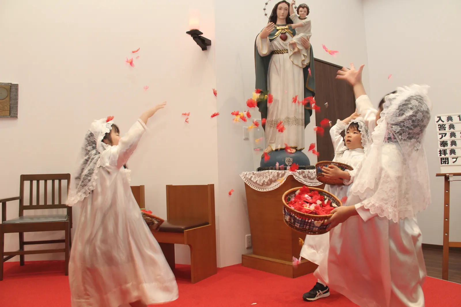 マリア祭で聖母像に花びらをささげる子どもたち